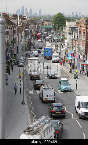 La congestione del traffico su Lee Bridge Road, occupato suburban high street a Londra del nord. London skyline della città in background Foto Stock