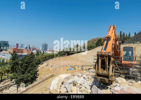 Macchina raccogliendo grandi rocce di granito in cantiere a Barcellona, in Catalogna, Spagna Foto Stock