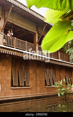 Un membro dello staff richiama le persiane del secondo piano lounge per lasciare entrare la luce del mattino presso La Residence d'Angkor, Siem Reap Foto Stock