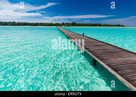 Legno lungo molo su laguna in Maldive con incredibile acqua pulita Foto Stock