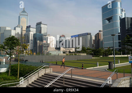 Dh Tamar Park ADMIRALTY HONG KONG uomo a fare jogging nel parco e Wanchai grattacieli pareggiatore asia Foto Stock