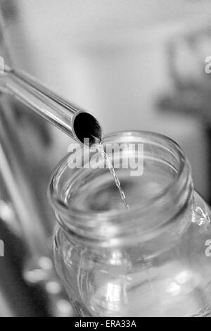 L'alcol versando in vaso di prova alla distilleria artigianale. Verticale B/W fotografia a Key West distillando, Key West, Florida, Stati Uniti d'America Foto Stock