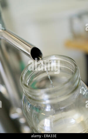 L'alcol versando in vaso di prova alla distilleria artigianale. Verticale fotografia a colori a Key West distillando, Key West, Florida, Stati Uniti d'America Foto Stock