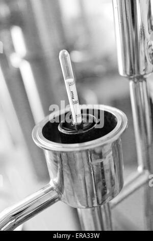 Alcolometro galleggianti in alcole a craft Distillery. Verticale B/W fotografia a Key West distillando, Key West, Florida, Stati Uniti d'America Foto Stock