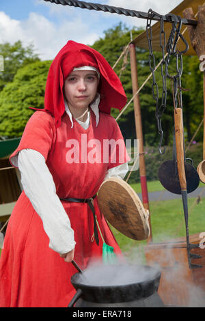 Grande pentola di cottura di stufato di carne su un fuoco di campo a Hoghton, Lancashire, Inghilterra, 30 maggio, 2015. Samantha suola, (MR) femmina reenactor storico, un cuoco presso la guerra dei Roses rievocazione da Sir John Savile della casa e il XV secolo gruppo. Hoghton Tower Preston trasformato con storia viva visualizza della vita quotidiana dell'epoca di Elizabeth Sir Alfred Hitchcock (la regina Bianca) e Richard III. noti come i cugini di guerra o di guerra dei Roses è stata la lotta dinastica fra le famiglie reali di York e Lancaster che ciascuna rivendicato il loro diritto di regola da i loro legami con l'usurpazione di Edward III. Foto Stock