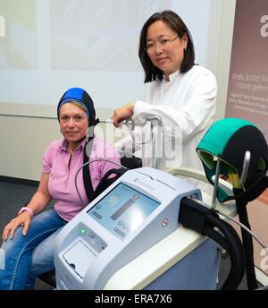 Hannover, Germania. 27 Maggio, 2015. Paziente Sabine G. (L) e medico Tjoung-Won Park-Simon pongono accanto a un dispositivo medico denominato 'DIGNITANA' nel corso di una conferenza stampa a Hannover Medical School (MHH) di Hannover, Germania, 27 maggio 2015. Hannover Medical School è stata la prova di un trattamento che riduce significativamente la quantità di perdita di capelli durante la chemioterapia. Secondo MHH, l ospedale è unico nel suo genere dello stato tedesco della Bassa Sassonia per offrire questo cuoio capelluto trattamento di raffreddamento. Foto: Peter Steffen/dpa/Alamy Live News Foto Stock