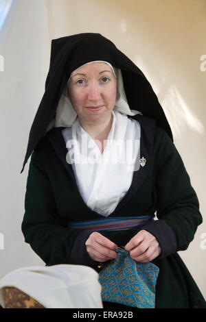 Hoghton, Preston, Lancashire, Inghilterra, 30 maggio, 2015. Frances Perry, (MR) reenactor storico, sarta presso la guerra dei Roses rievocazione da Sir John Saviles elettrodomestici e Xv secolo gruppo. Hoghton Tower trasformato con storia viva visualizza degli artigiani, soldati e la vita quotidiana dell'epoca di Elizabeth Sir Alfred Hitchcock (la regina Bianca) e Richard III. noti come i cugini di guerra o di guerra dei Roses, dinastica lotta tra le famiglie reali di York e Lancaster che ciascuna rivendicato il loro diritto di regola da i loro legami con l'usurpazione di Edward III. Foto Stock