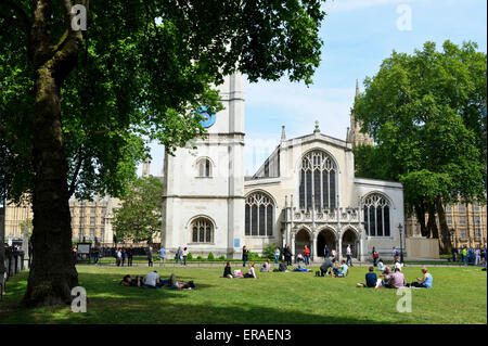 Le persone sono seduti sul prato fuori chiesa di St Margaret, Londra, Inghilterra. Foto Stock