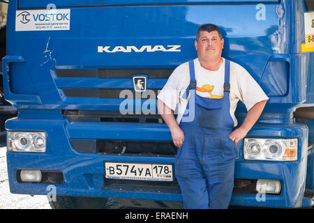 San Pietroburgo, Russia - 30 Maggio 2015: positivo il camionista si erge nei pressi del suo Kamaz blu cabina del camion Foto Stock