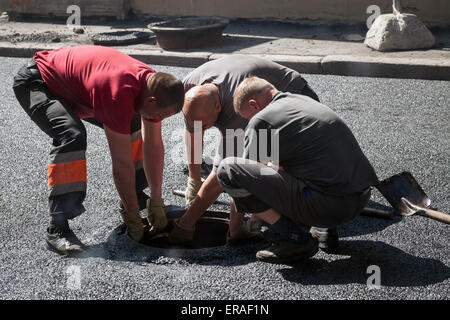 San Pietroburgo, Russia - 30 Maggio 2015: uomini al lavoro, strada urbana in costruzione, asfaltatura in corso Foto Stock