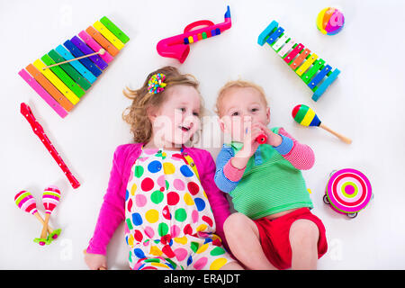 Bambino con strumenti musicali. Educazione musicale per i bambini. Colorata arte in legno giocattoli per bambini. Bambina e ragazzo riprodurre musica. Foto Stock