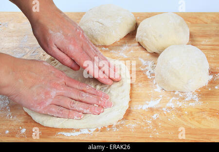 Uomo con le mani in mano la preparazione di impasto per pizza Foto Stock