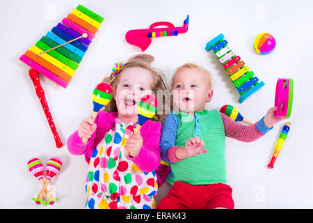 Bambino con strumenti musicali. Educazione musicale per i bambini. Colorata arte in legno giocattoli per bambini. Bambina e ragazzo riprodurre musica. Foto Stock