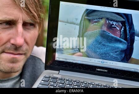 Eisleben, Germania. Il 20 maggio 2015. Hitchhiker Gregor Majewski guarda una foto di sé in Siberia durante uno dei suoi ultimi tours, a Eisleben, Germania, 20 maggio 2015. L'insegnante è stata autostop per oltre venti anni e ha coperto oltre 300.000 chilometri. Uno dei suoi ultimi viaggi ha preso lui attraverso lo stretto di Bering in Alaska e in Sud America. Foto: Hendrik Schmidt/dpa/Alamy Live News Foto Stock