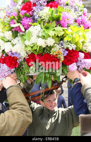 Tocchi di finitura sono realizzati per la ghirlanda floreale fatta di acconciatura per celebrare la quercia giorno Apple, Castleton Derbyshire, Regno Unito Foto Stock