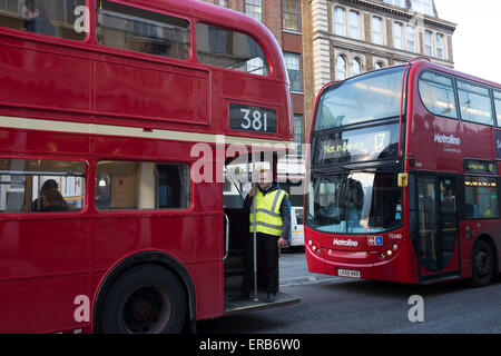 Conduttore di autobus sorge sul piede piatto di un vecchio rosso autobus Routemaster a Londra, Bridge, Regno Unito. Questo stile di "hop on hop off'. Foto Stock