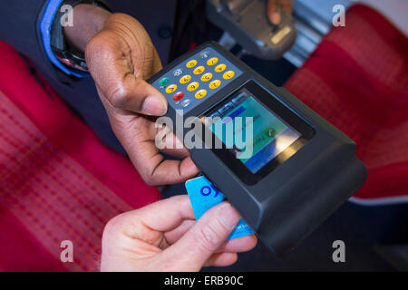 Ispettore controlli / legge Oyster Card Ticket con lettore su SW treni overground treno valido anche LT bus /metropolitana travel Foto Stock