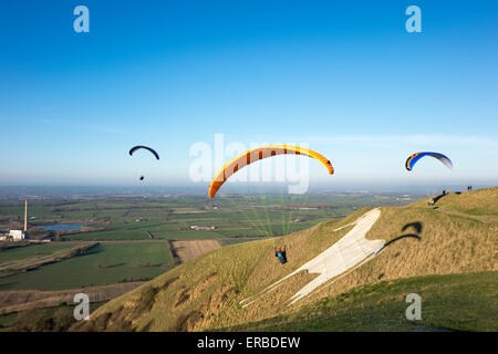 Parapendio volo sopra il Westbury Cavallo Bianco nel Wiltshire, Regno Unito. Foto Stock