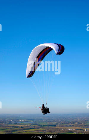 Un parapendio volo sopra il Westbury Cavallo Bianco nel Wiltshire, Regno Unito. Foto Stock