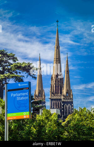 Il Parlamento stazione è una stazione della metropolitana sulla metropolitana di Melbourne Loop contro bluestone Revival gotico Cattedrale di St Patrick. Foto Stock