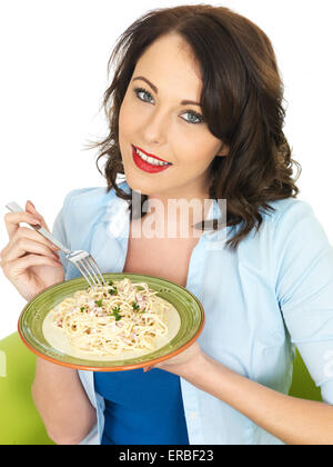 Felice sorridente bella giovane donna nei suoi anni venti che tiene un piatto di spaghetti Carbonara Pasta Foto Stock