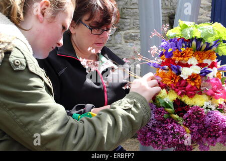 Garland maker mettere i tocchi di rifinitura per il copricapo floreale indossati dal Garland re per celebrare la quercia giorno Apple, Castleton Foto Stock