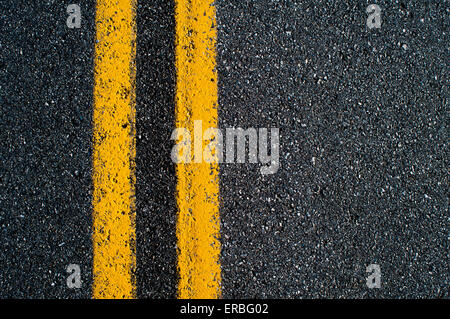 Un doppio giallo "no passando' linea su una strada asfaltata. Foto Stock