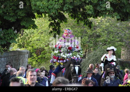 Indossa un copricapo floreale, la ghirlanda re e la sua consorte ride through Castleton per celebrare la quercia giorno Apple, Peak District UK Foto Stock