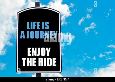 La vita è un viaggio Godetevi il viaggio motivazionale di preventivo scritto sul cartello stradale isolato oltre il cielo azzurro sfondo Foto Stock