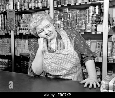 1930s donna che indossa un grembiule bianco latte tenuto fuori dal  frigorifero Foto stock - Alamy