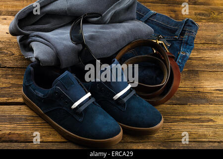 Blu scuro scarpe da uomo, jeans, pullover felpa con cappuccio Felpa e accessori su sfondo di legno Foto Stock