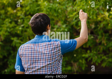 Indietro man mano che scrive in aria su uno sfondo verde street tr Foto Stock