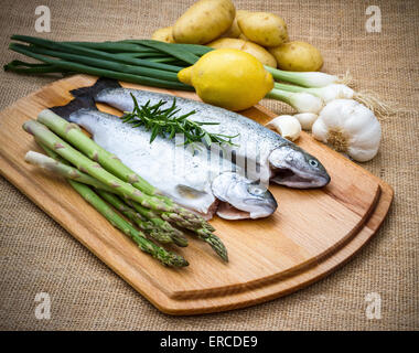 Trota di greggio con asparagi verdi, limone e ingredienti, vista dall'alto Foto Stock