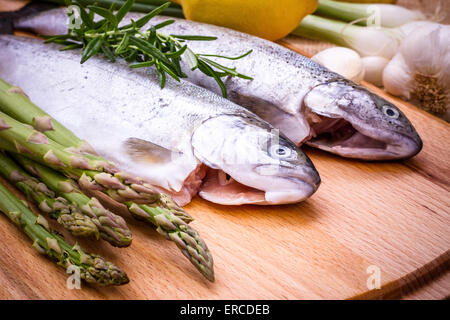 Trota di greggio con asparagi verdi, limone e rosmarino, close up Foto Stock