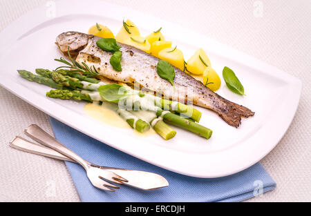 Trota alla griglia con asparagi verdi e rosmarino patate, salsa olandese Foto Stock