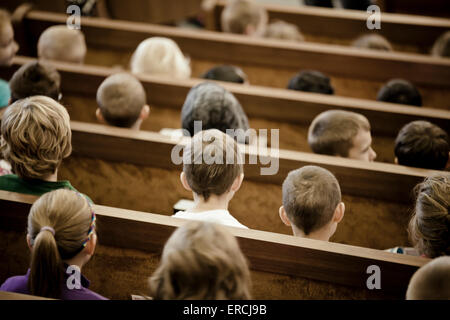 gli studenti delle scuole si siedono sulle panchine durante l'assemblea. Foto Stock