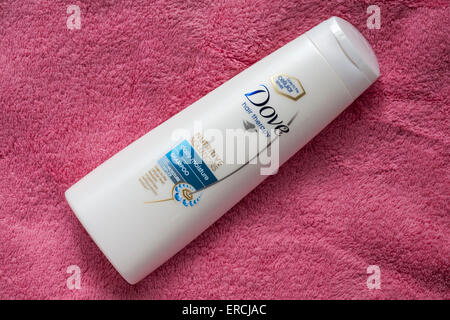 Bottiglia di Colomba terapia capelli soluzioni nutritive umidità giornaliera shampoo sul tovagliolo di rosa Foto Stock