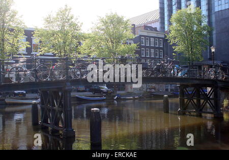 Un sacco di biciclette parcheggiate su un vecchio ghisa ponte a Nieuwe Achtergracht canal, Amsterdam, Paesi Bassi Foto Stock