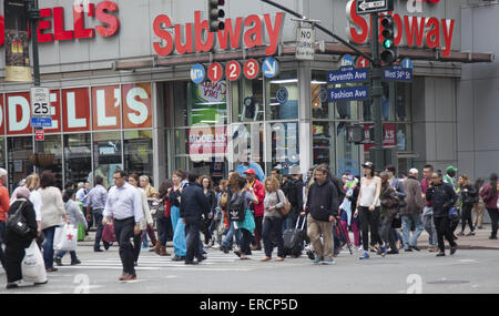 Ci sono sempre folle sulla strada a 7th Avenue e la 34th Street in NYC. Foto Stock