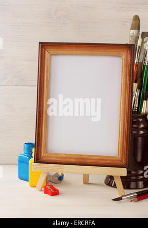 Cornice foto e vernici su sfondo di legno Foto Stock