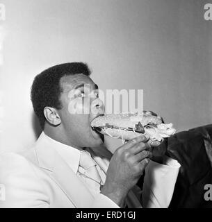 Muhammad Ali il labbro di Louisville tacitato da una torta Stottie, un tradizionale Geordie delicatezza farcite con lattuga, cipolla, cetriolo e pomodoro. Scattare foto durante il suo giro di Tyneside Newcastle. 16 Luglio 1977 Foto Stock