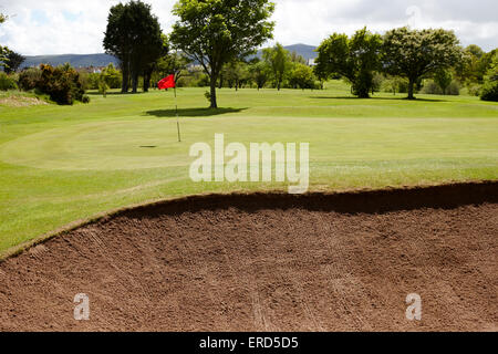 Vista del foro bandiera dal bunker di sabbia a Cushendall Golf Club nella contea di Antrim Irlanda del Nord Regno Unito Foto Stock