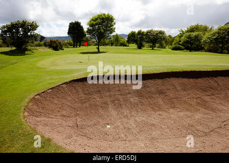 Vista del foro bandiera dal bunker di sabbia a Cushendall Golf Club nella contea di Antrim Irlanda del Nord Regno Unito Foto Stock