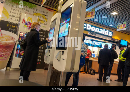 Aeroporto di Dublino, Irlanda. Il 1 giugno, 2015. McDonalds hanno installato auto-ordine chioschi in corrispondenza di un certo numero di loro ristoranti in Irlanda di recente. Essi sono controversi come essi eliminano la necessità di impiegare personale di servizio o i cassieri. Le persone utilizzano schermi tattili per ordinare i loro pasti utilizzando contactless o convenzionali di pagamento tramite carta di credito. Credito: Richard Wayman/Alamy Live News Foto Stock