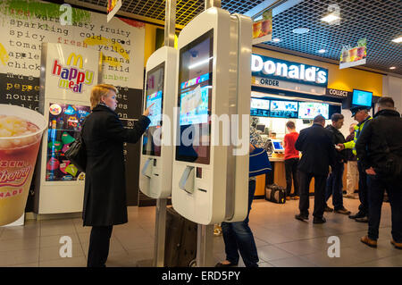 Aeroporto di Dublino, Irlanda. Il 1 giugno, 2015. McDonalds hanno installato auto-ordine chioschi in corrispondenza di un certo numero di loro ristoranti in Irlanda di recente. Essi sono controversi come essi eliminano la necessità di impiegare personale di servizio o i cassieri. Le persone utilizzano schermi tattili per ordinare i loro pasti utilizzando contactless o convenzionali di pagamento tramite carta di credito. Credito: Richard Wayman/Alamy Live News Foto Stock