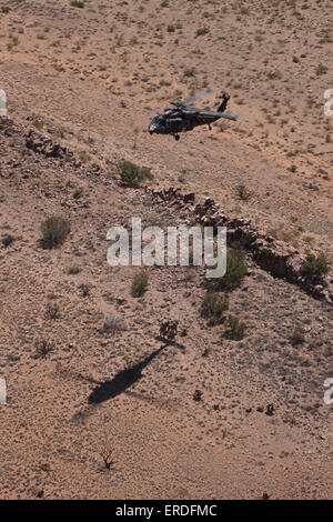 UH-60 Black Hawk si libra sopra U.S. Marines come si preparano per estrarre una simulazione di incidente mediante un paranco durante l'esercizio Angelo Thunde Foto Stock