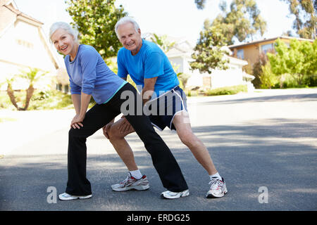 Uomo anziano e più giovane donna jogging Foto Stock