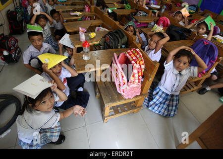 Paranaque City, Filippine. 2 Giugno, 2015. Agli studenti di coprire le loro teste durante un terremoto praticare in una scuola di Paranaque City, Filippine, Giugno 2, 2015. © Rouelle Umali/Xinhua/Alamy Live News Foto Stock