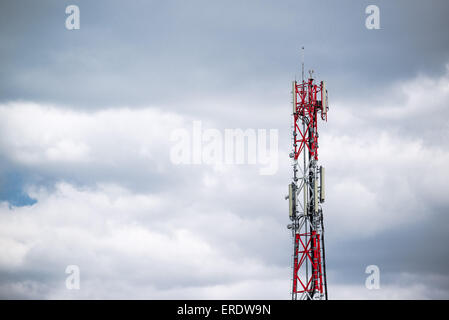 Antenna GSM trasmettitori su rosso e bianco industriale torre di comunicazione Foto Stock