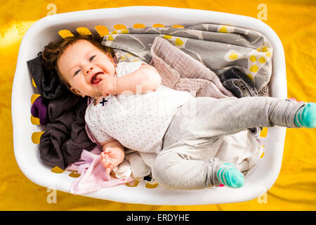 Caucasian Baby girl posa in un cesto della biancheria Foto Stock